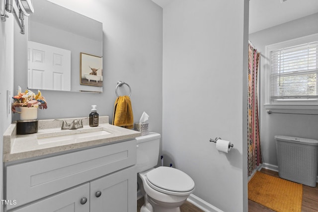 bathroom with vanity, toilet, and wood-type flooring