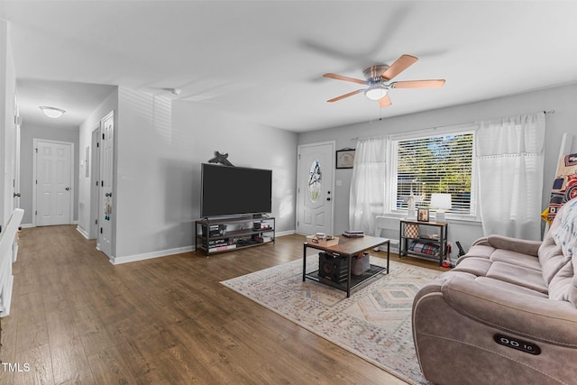 living room with ceiling fan and dark wood-type flooring