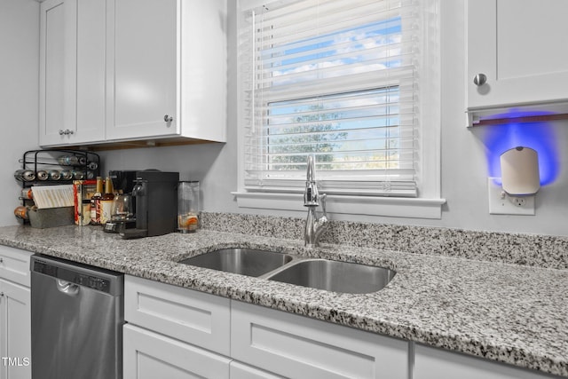 kitchen featuring dishwasher, light stone counters, white cabinetry, and sink