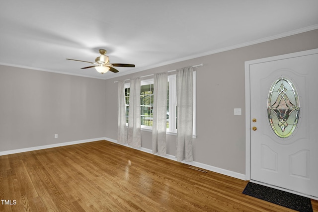 foyer featuring hardwood / wood-style flooring, ceiling fan, and ornamental molding