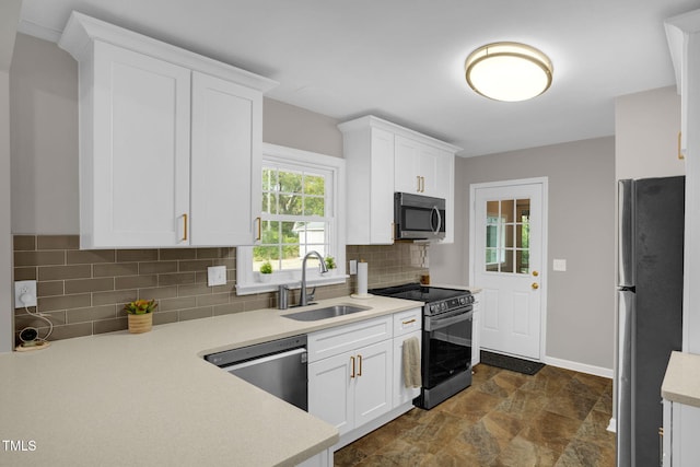 kitchen with white cabinets, sink, stainless steel appliances, and tasteful backsplash