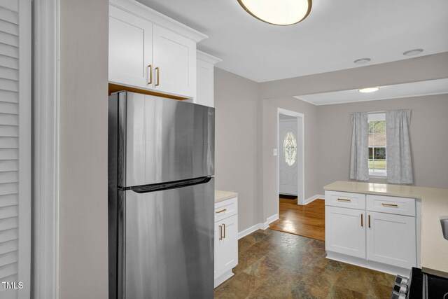 kitchen featuring stainless steel fridge and white cabinetry