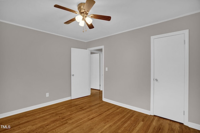 empty room featuring ceiling fan, hardwood / wood-style floors, and ornamental molding