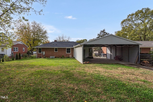 rear view of property with a lawn and a carport