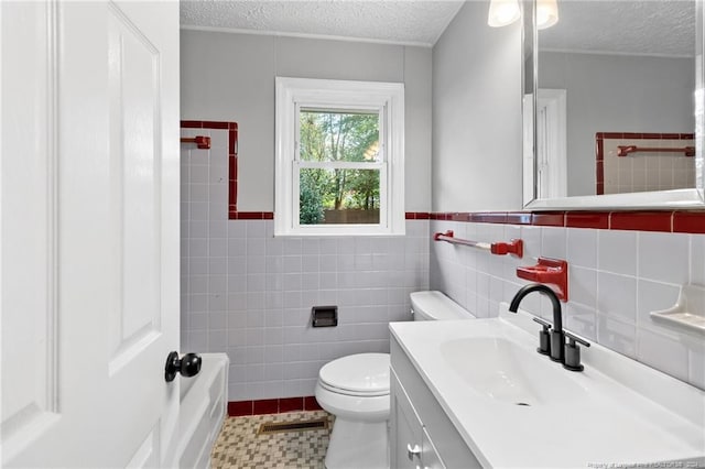 bathroom featuring a textured ceiling, tile patterned flooring, vanity, and tile walls