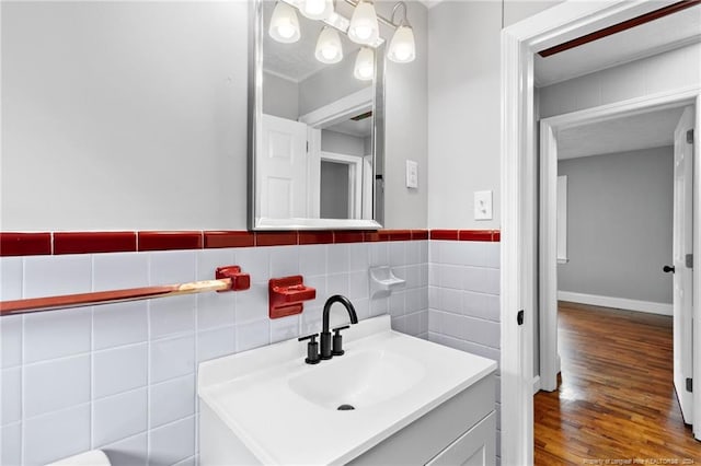 bathroom featuring hardwood / wood-style floors, vanity, and tile walls