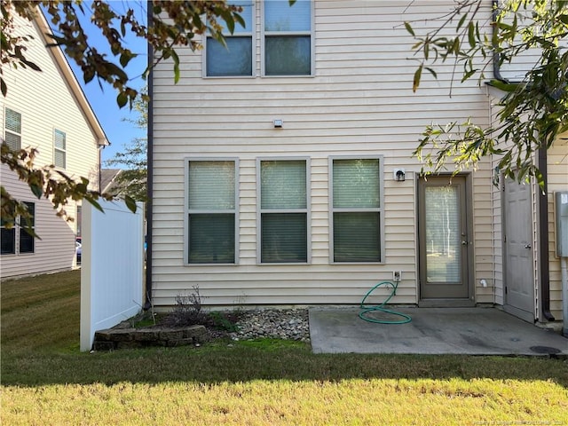 back of property featuring a patio and a lawn