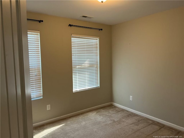 unfurnished room featuring light carpet