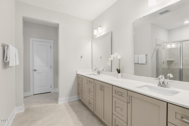 bathroom featuring tile patterned flooring, vanity, and a shower with door