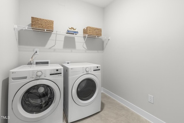 laundry room with light tile patterned floors and washing machine and clothes dryer