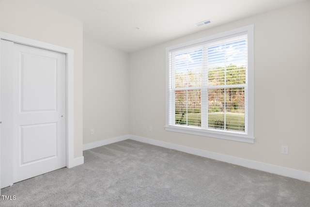 unfurnished bedroom featuring light carpet and a closet