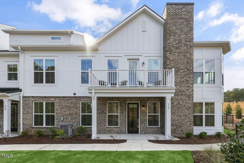 11549 Helmond Way Unit 114, Raleigh, NC 27617 - view of front facade featuring a balcony, central air condition unit, brick siding, board and batten siding, and covered porch