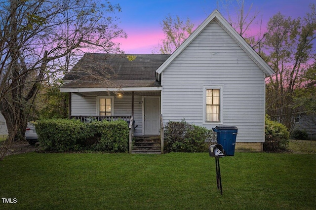 view of front facade featuring covered porch and a yard