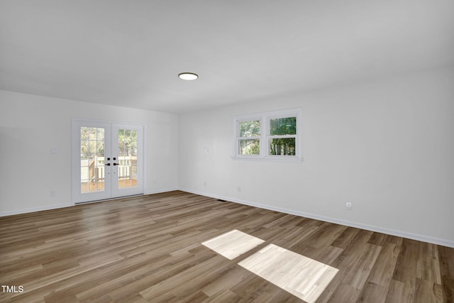 unfurnished room with french doors and light hardwood / wood-style floors