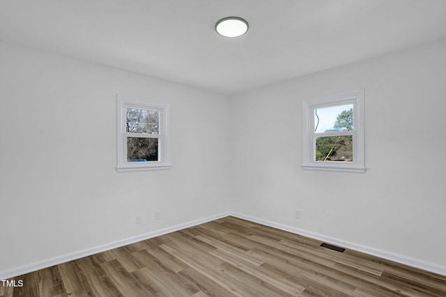 empty room with light hardwood / wood-style flooring and a healthy amount of sunlight