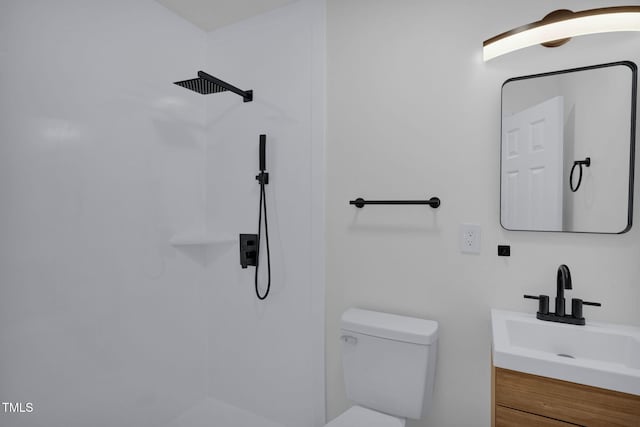 bathroom featuring vanity, toilet, and a shower