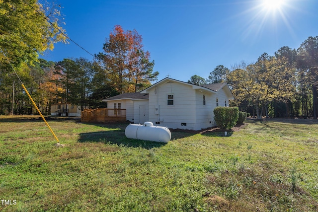 view of side of property featuring a lawn and a deck