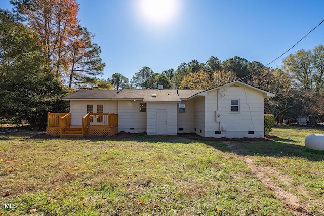 back of property with a lawn and a wooden deck