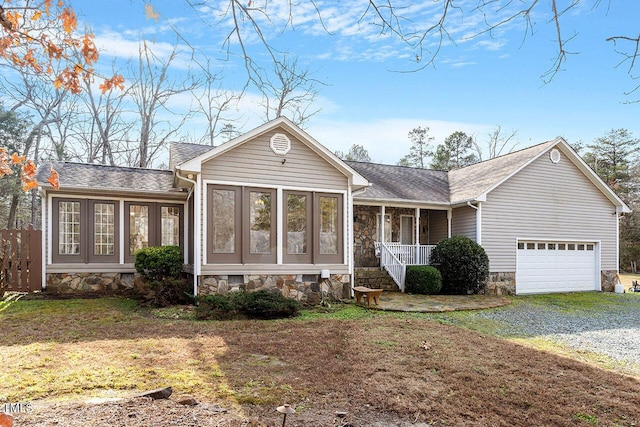 ranch-style home with a porch, a front yard, and a garage