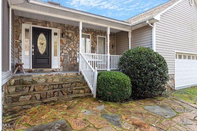 property entrance with covered porch and a garage