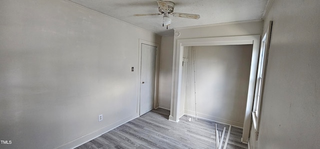 unfurnished bedroom featuring light wood-type flooring, a closet, ceiling fan, and ornamental molding