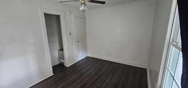 unfurnished bedroom with ceiling fan and dark wood-type flooring