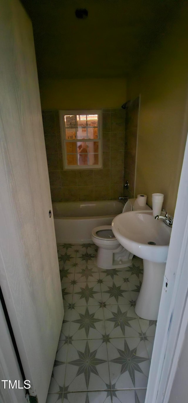 bathroom featuring toilet and tiled shower / bath