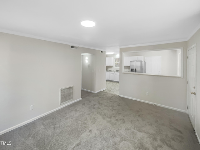 unfurnished living room featuring light carpet and crown molding