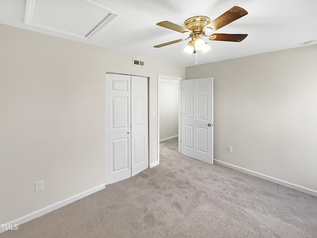 unfurnished bedroom with ceiling fan, light carpet, and a closet