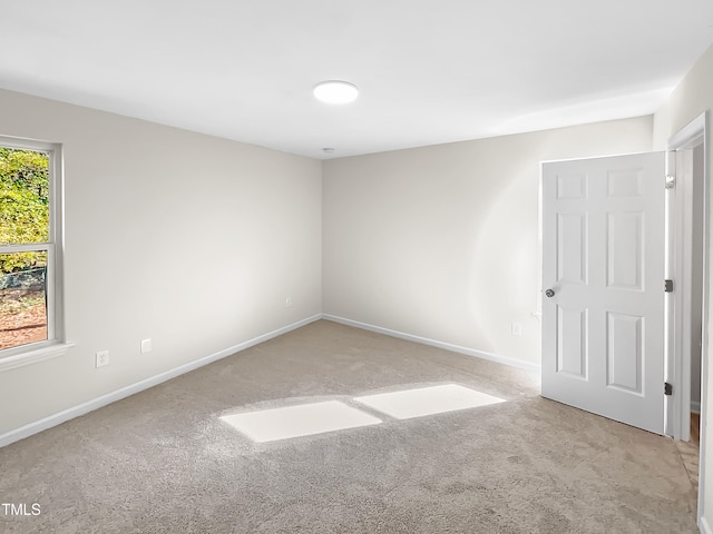 unfurnished room with light colored carpet and a wealth of natural light