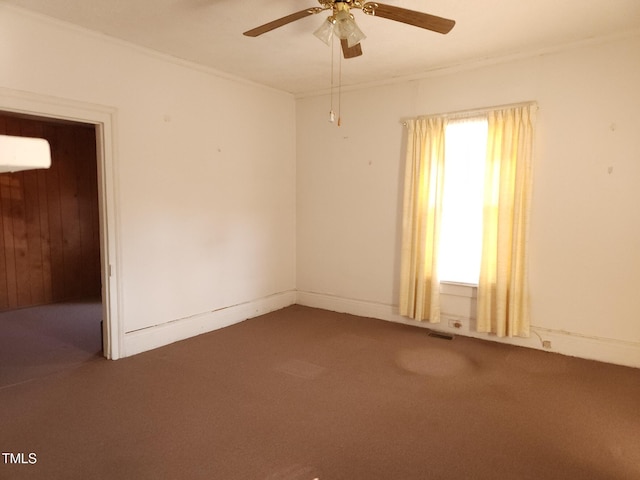 empty room featuring carpet flooring, ceiling fan, and crown molding