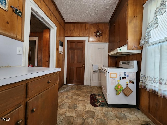 kitchen featuring a textured ceiling, white stove, washer / clothes dryer, and wooden walls