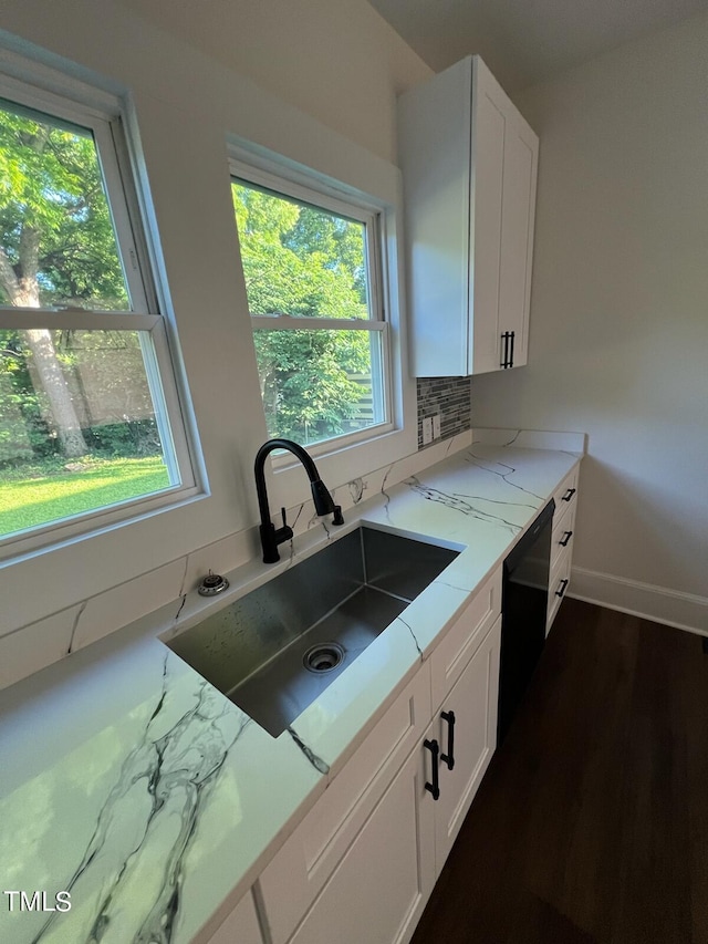 kitchen with dishwasher, sink, light stone counters, dark hardwood / wood-style flooring, and white cabinets