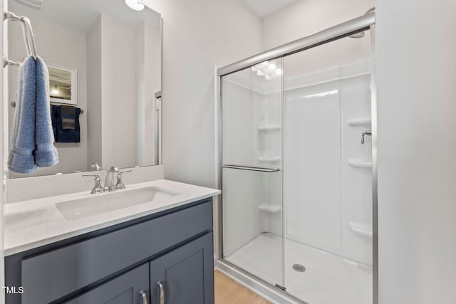 bathroom featuring hardwood / wood-style floors, vanity, and an enclosed shower