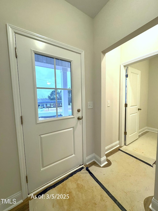 doorway to outside featuring baseboards