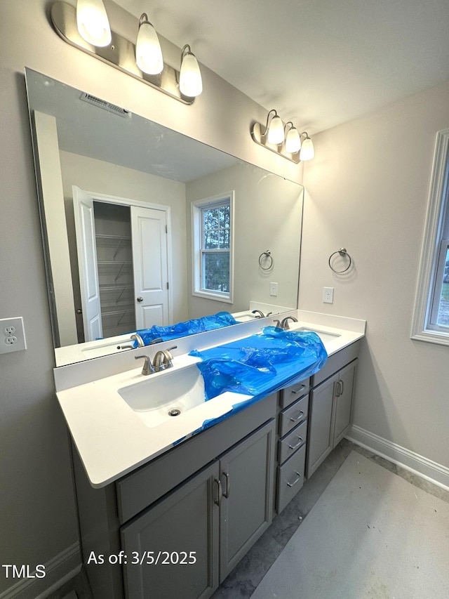 full bathroom featuring double vanity, a sink, visible vents, and baseboards