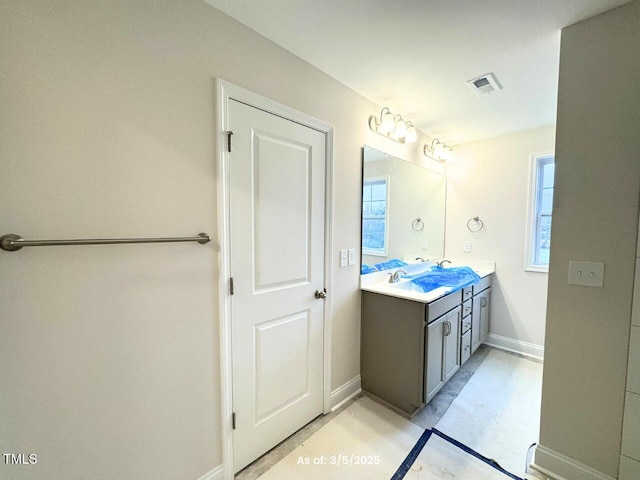 bathroom featuring visible vents, a sink, baseboards, and double vanity