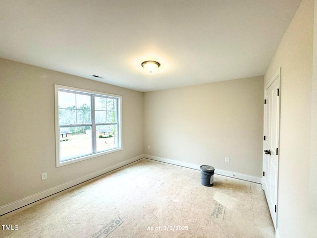 empty room featuring baseboards and visible vents