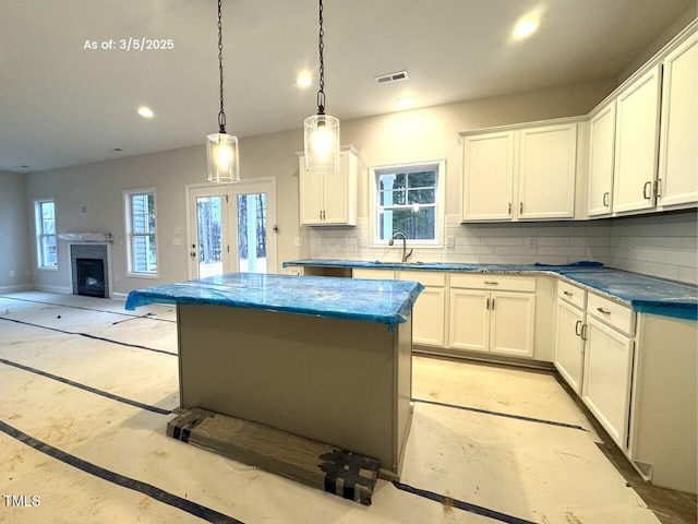 kitchen featuring recessed lighting, white cabinetry, visible vents, decorative backsplash, and a center island