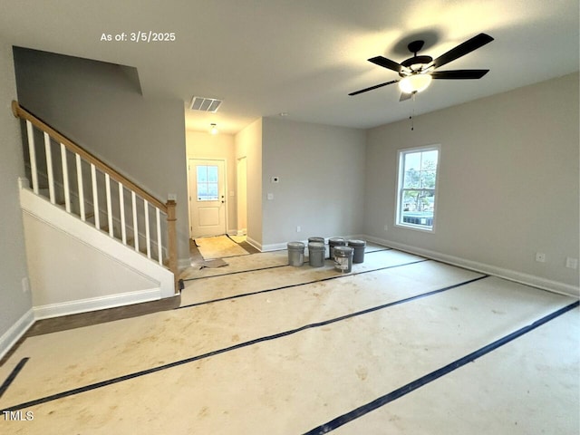 foyer entrance with a ceiling fan, visible vents, stairway, and baseboards