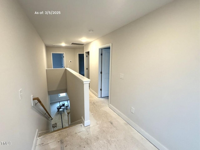 hall featuring visible vents, an upstairs landing, and baseboards