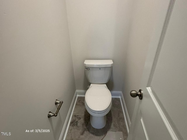 bathroom featuring baseboards and toilet