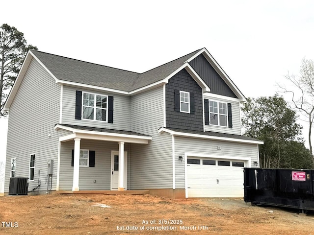 view of front of home with a garage, dirt driveway, and central air condition unit