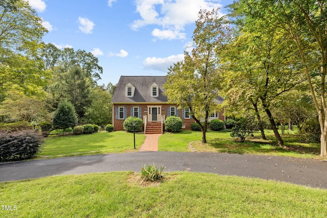 cape cod house featuring a front yard