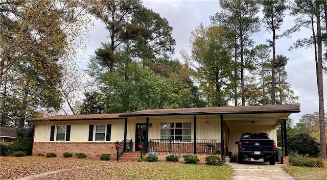 ranch-style home featuring covered porch and a carport