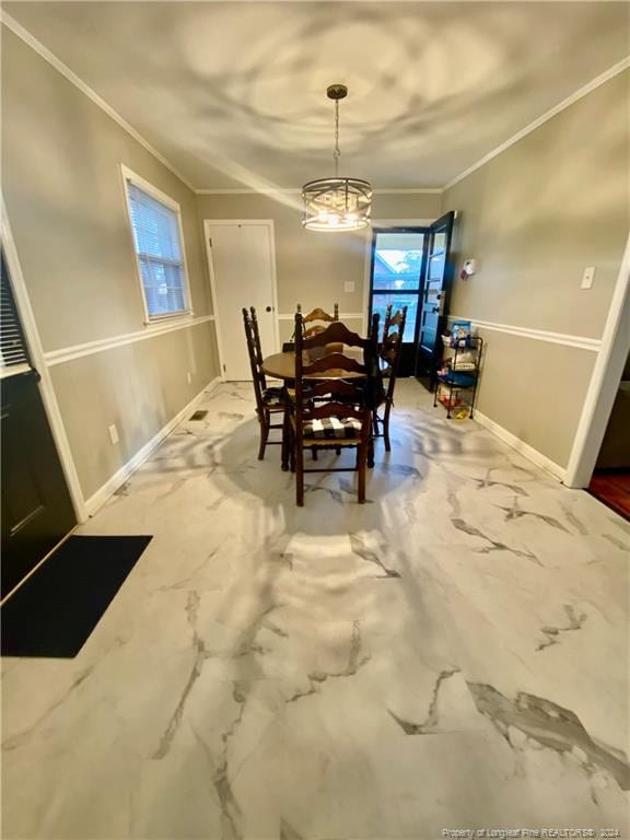 dining space featuring crown molding and a chandelier