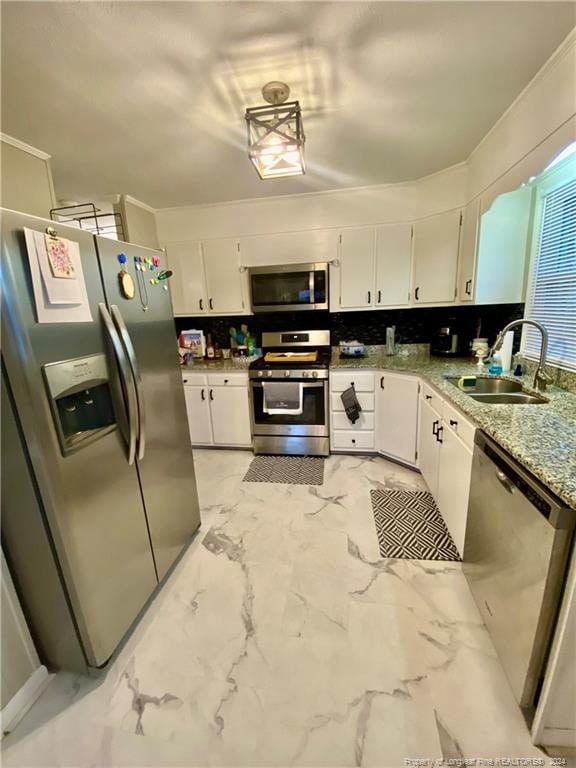 kitchen featuring stainless steel appliances, white cabinetry, tasteful backsplash, and sink