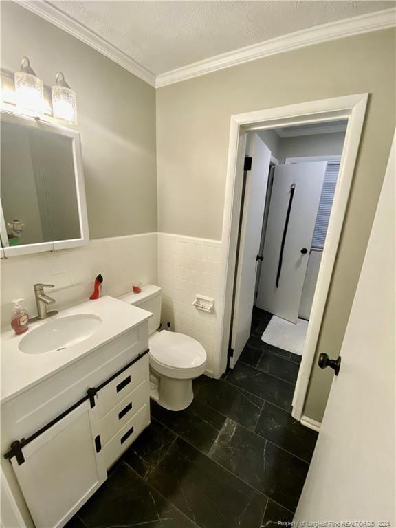 bathroom featuring crown molding, vanity, tile walls, and toilet