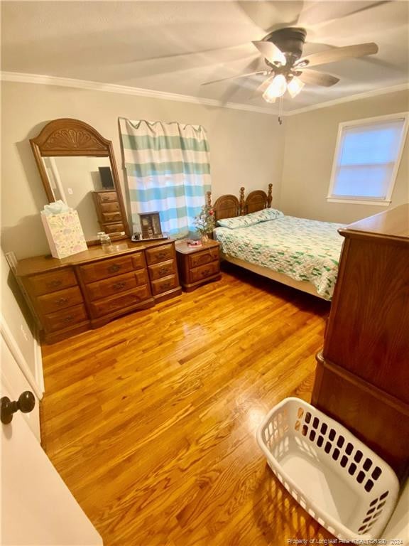 bedroom with hardwood / wood-style flooring, ceiling fan, and ornamental molding