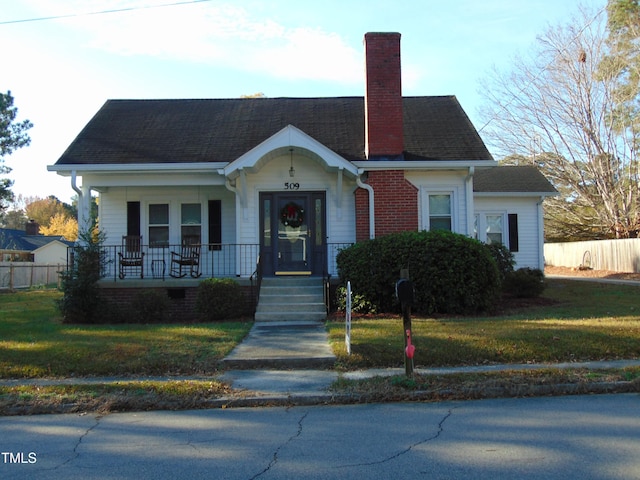 view of front of house featuring covered porch and a front yard